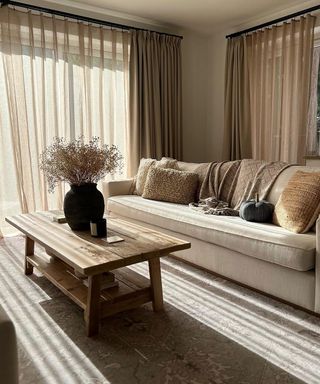 beige curtains with voile behind in living room with sofa and coffee table