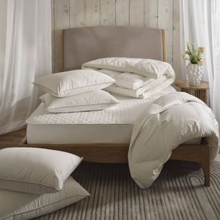 Wooden bedframe with mattress duvet and pillows