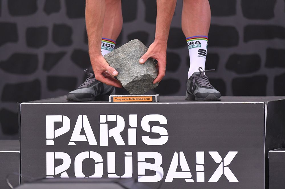 Peter Sagan places his cobble trophy on the podium after winning Paris-Roubaix