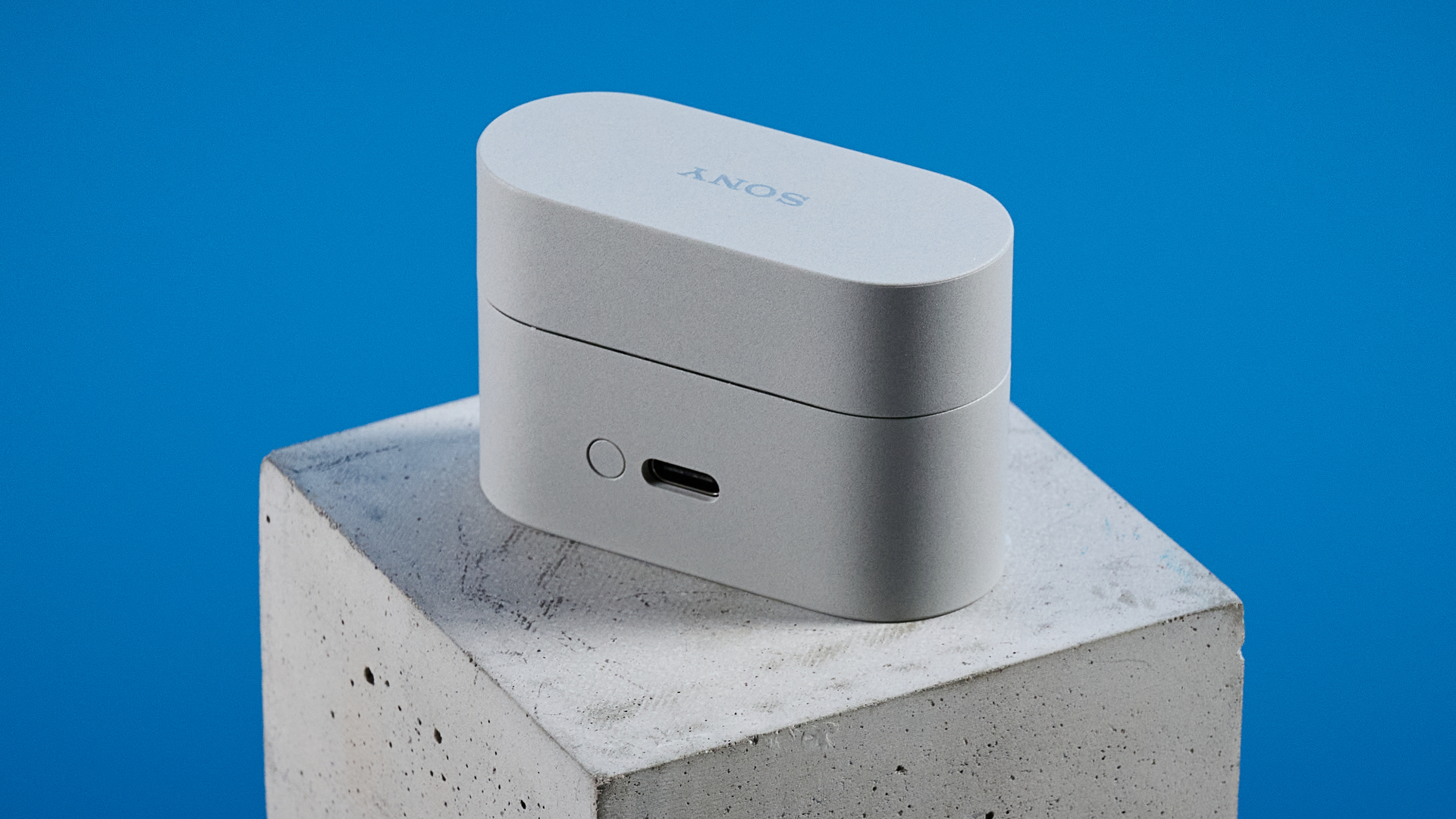 Sony WF-1000XM6 earbuds photographed in front of a blue background