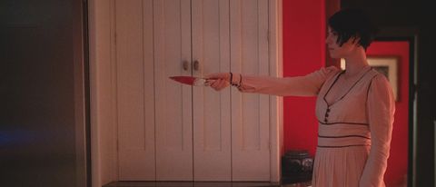 Jessie Buckley holding a knife in Men