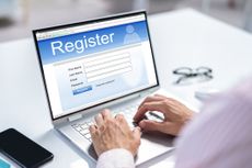 Businessman's Hand Filing Online Registration Form On Laptop