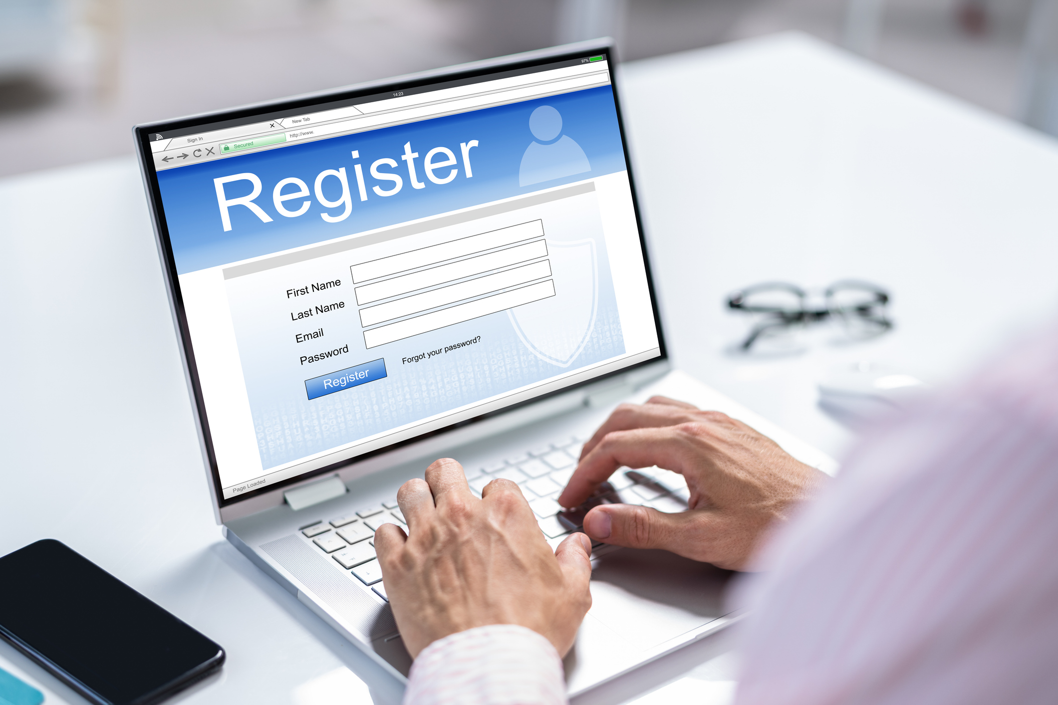 Businessman's Hand Filing Online Registration Form On Laptop