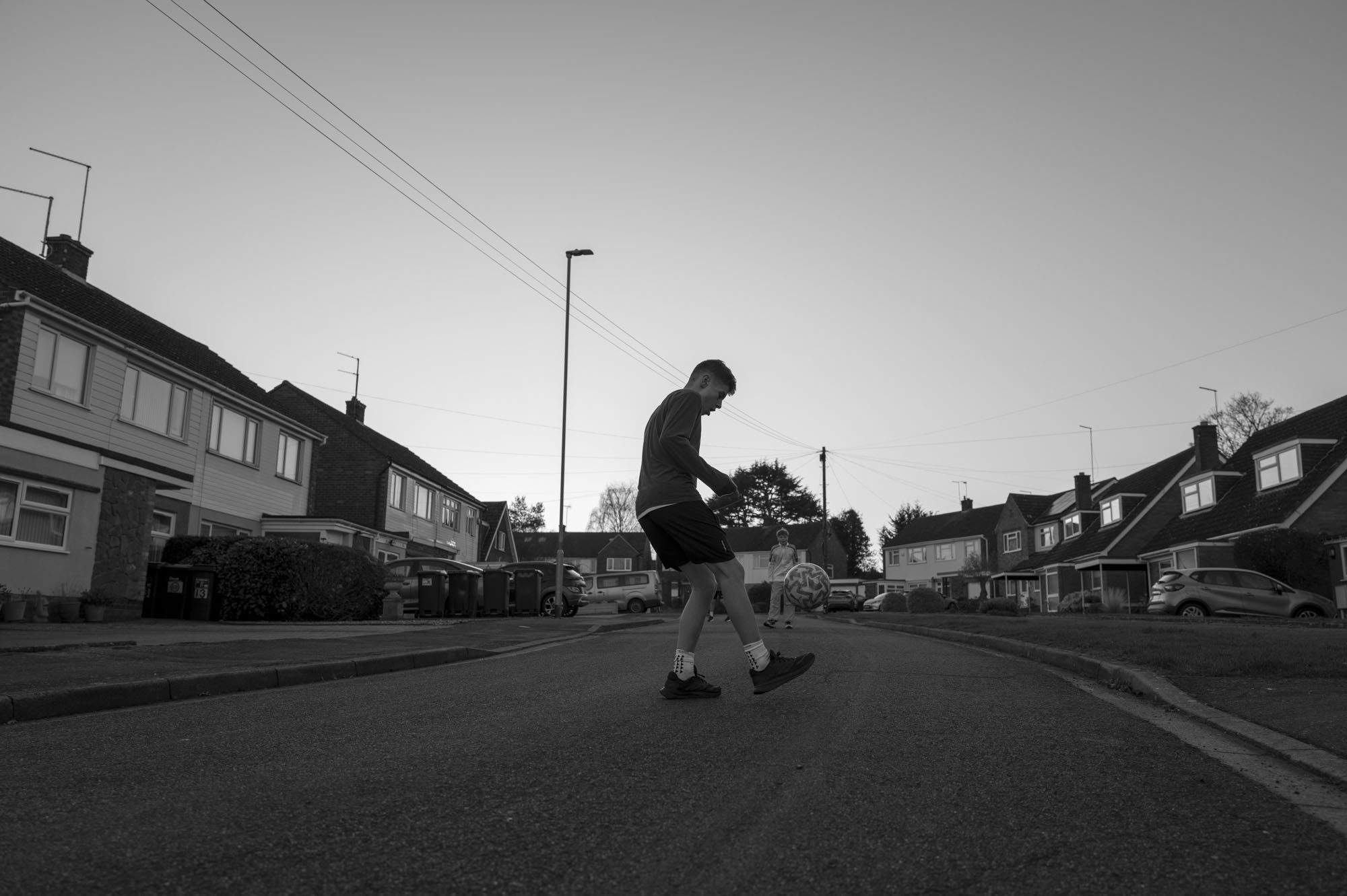 Leica Q3 Monochrom sample gallery: boy playing football in urban street