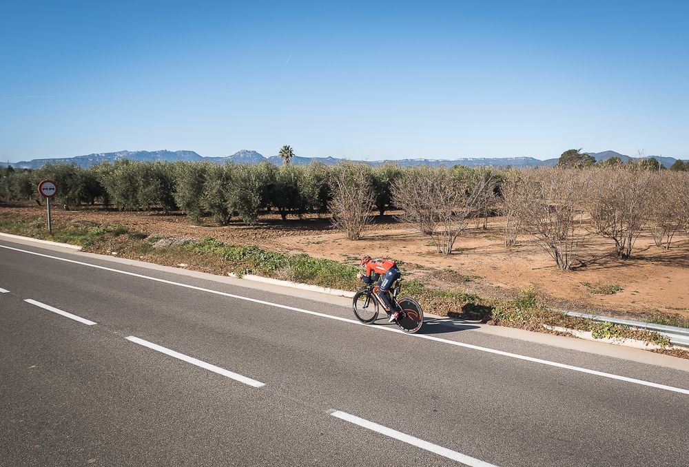 A Bahrain-Merida rider passes an orchard during his training.