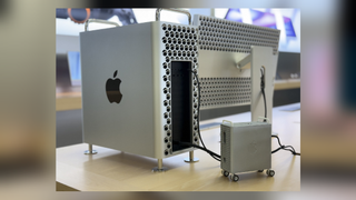 A Mac Pro looms over a Mac Mini that's be mounted in a 3D-printed case designed to look like a tiny Mac Pro.