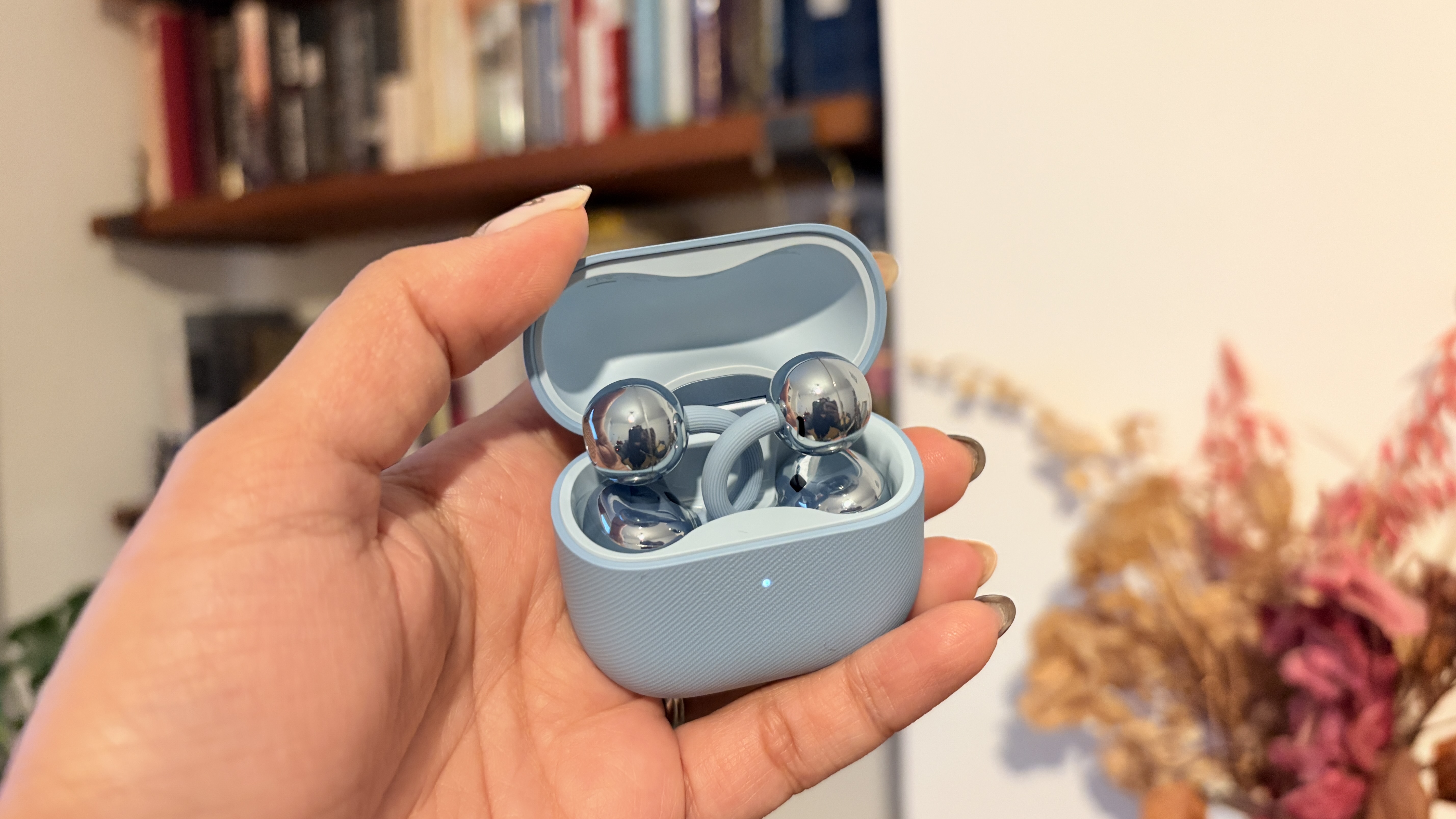 Huawei FreeClip 2 earbuds in blue finish, held in hand