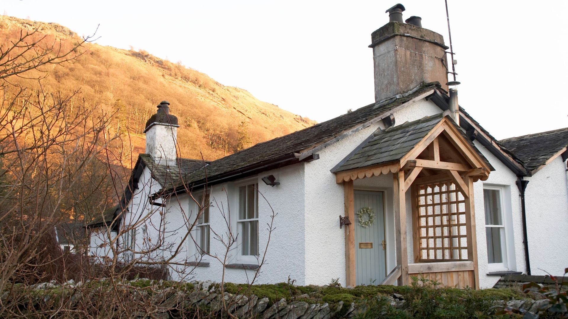 Picture of a countryside cottage with a wooden porch and wreath on the door