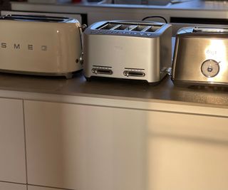 Smeg toaster next to two Breville toasters on the countertop