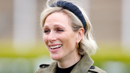  Zara Tindall, wearing an olive green trench coat, attends day 2 of the April Meeting at Cheltenham Racecourse on April 18, 2024