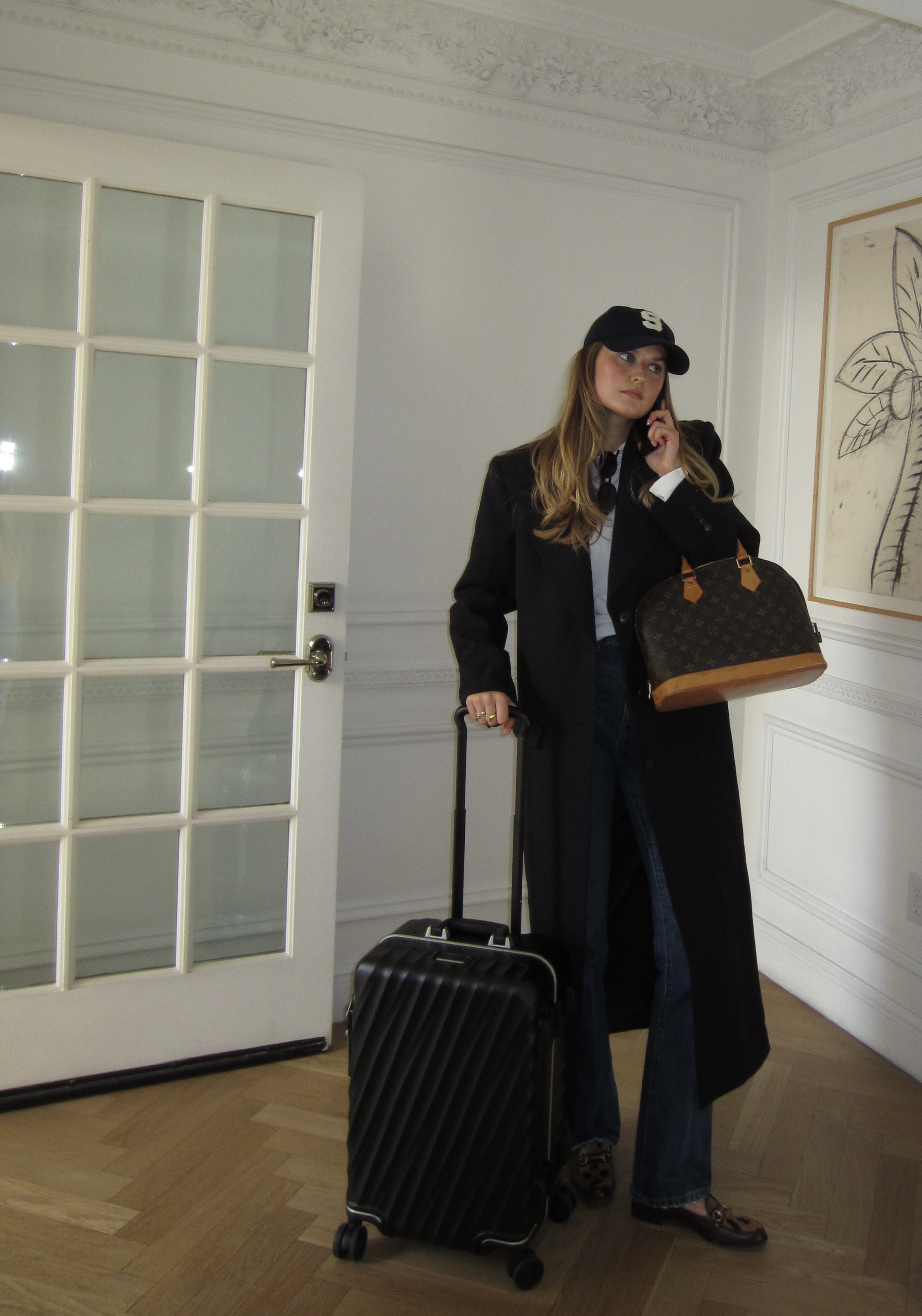 Sara Walker wearing a trench coat, jeans, and loafers.