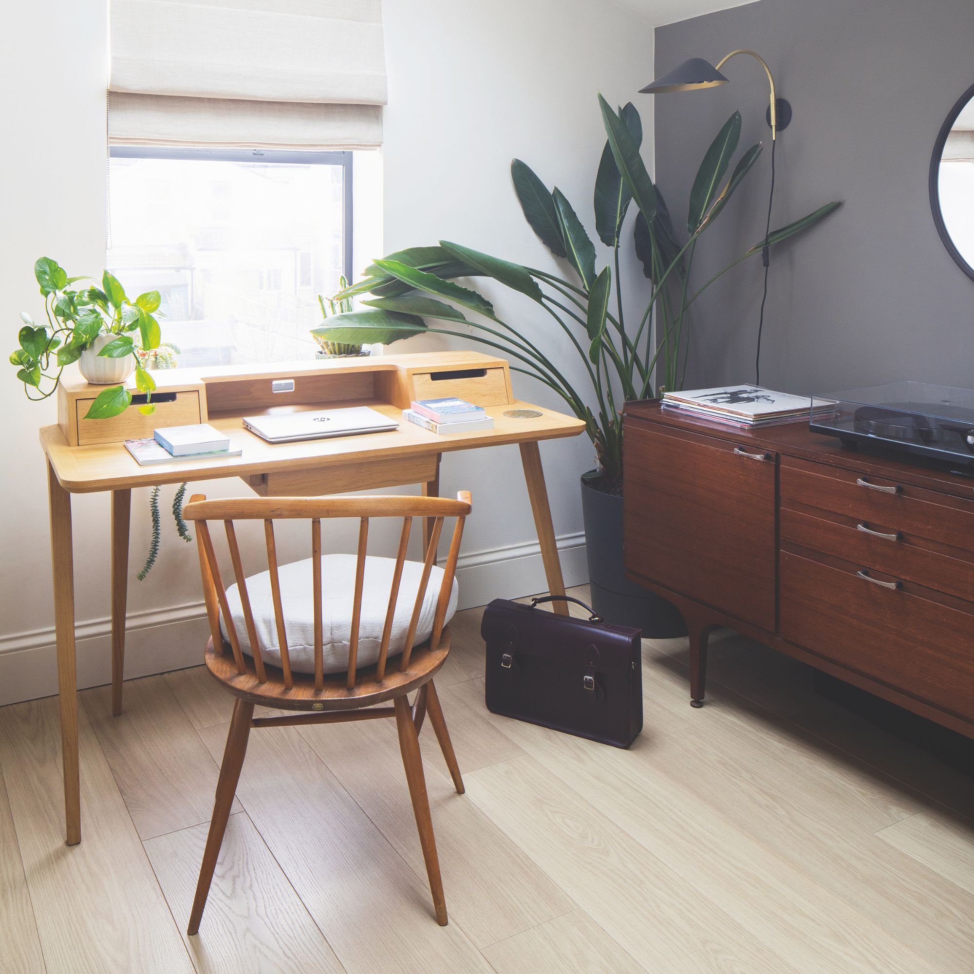 Home office with a wooden desk and matching chair in front of a window