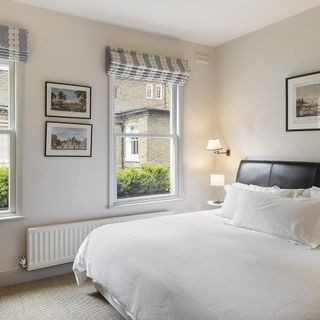 Inside the bedroom of Farnell Mews showing white walls and leather bed with white bedlinen