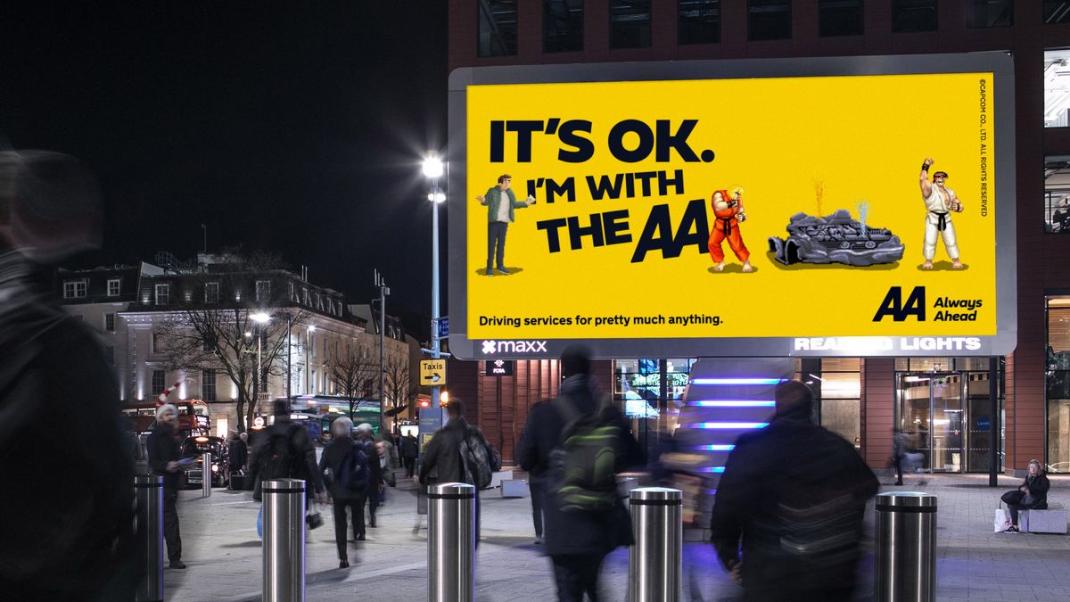 A yellow billboard featuring the characters Ken and Ryu from Street Fighter alongside bold black text that reads &quot;it&#039;s ok. I&#039;m with the AA&quot;