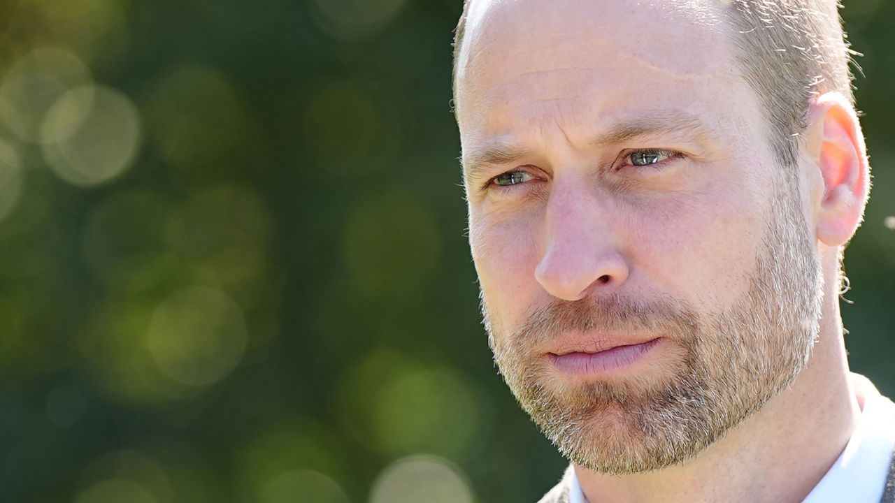 A headshot of Prince William looking serious and wearing a white dress shirt and gray blazer