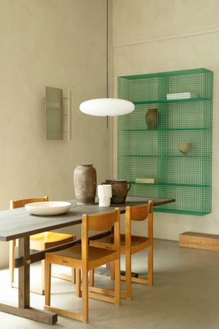 table and wooden chair with green cage shelves in background