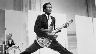 Rock and roll musician Chuck Berry does the splits as he plays his Gibson hollowbody electric guitar, circa 1968