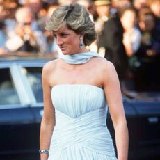 princess diana at the cannes film festival wearing a blue strapless dress with a sash around the neck