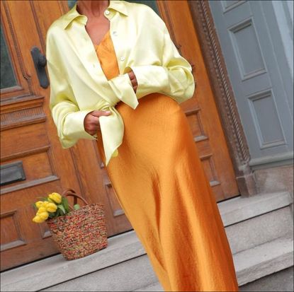 Grace Ghanem posing in orange silk dress and button down shirt