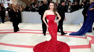 Kaitlyn Dever in a floor length red gown arriving at the 2023 Met Gala