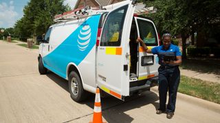 An AT&amp;T technician standing next to her van.