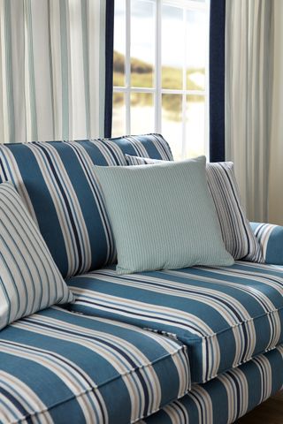 blue and white stripe sofa with stripe and plain cushions