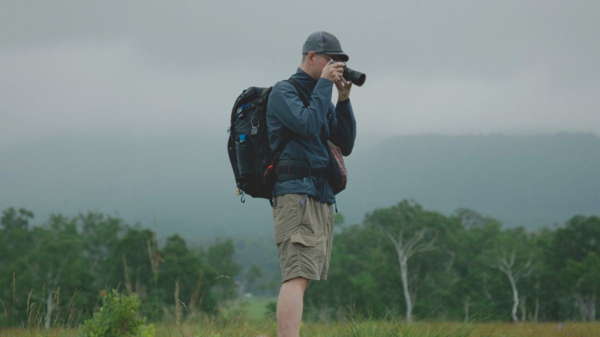 Sigma 50-120mm F2.8 DC OS Contemporary lens attached to a Canon camera, held by a photographer outdoors