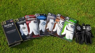 A cross section of footjoy golf gloves in packaging on a tee box