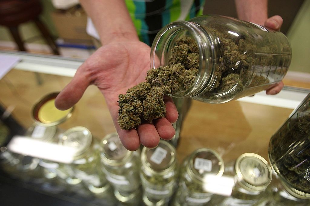 A bud tender at Private Organic Therapy, a nonprofit co-op medical marijuana dispensary in Los Angeles, displays various types of marijuana on Oct. 19, 2009.