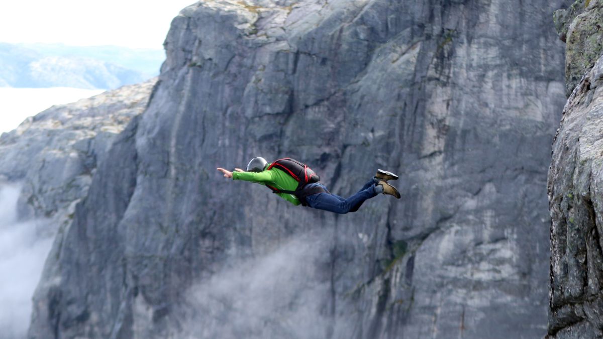 Man BASE jumping off mountain