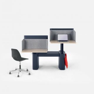 A desk with different levels for sitting or standing while working with a bucket chair with wheels in front of it.