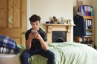 boy sitting on his bed