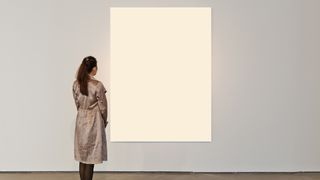 Woman at an art gallery looking at a plain white canvas