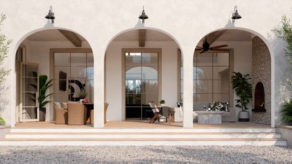 Bright home exterior with three large archways, revealing windows and outdoor porch with rattan furniture and tall plants.