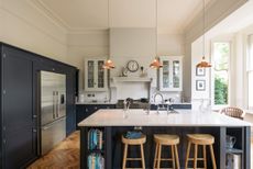 navy kitchen with an island and bar stools