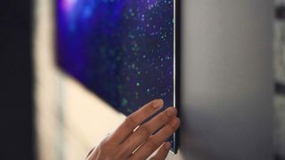 A close up of a person's hand touching the corner of the LG GX