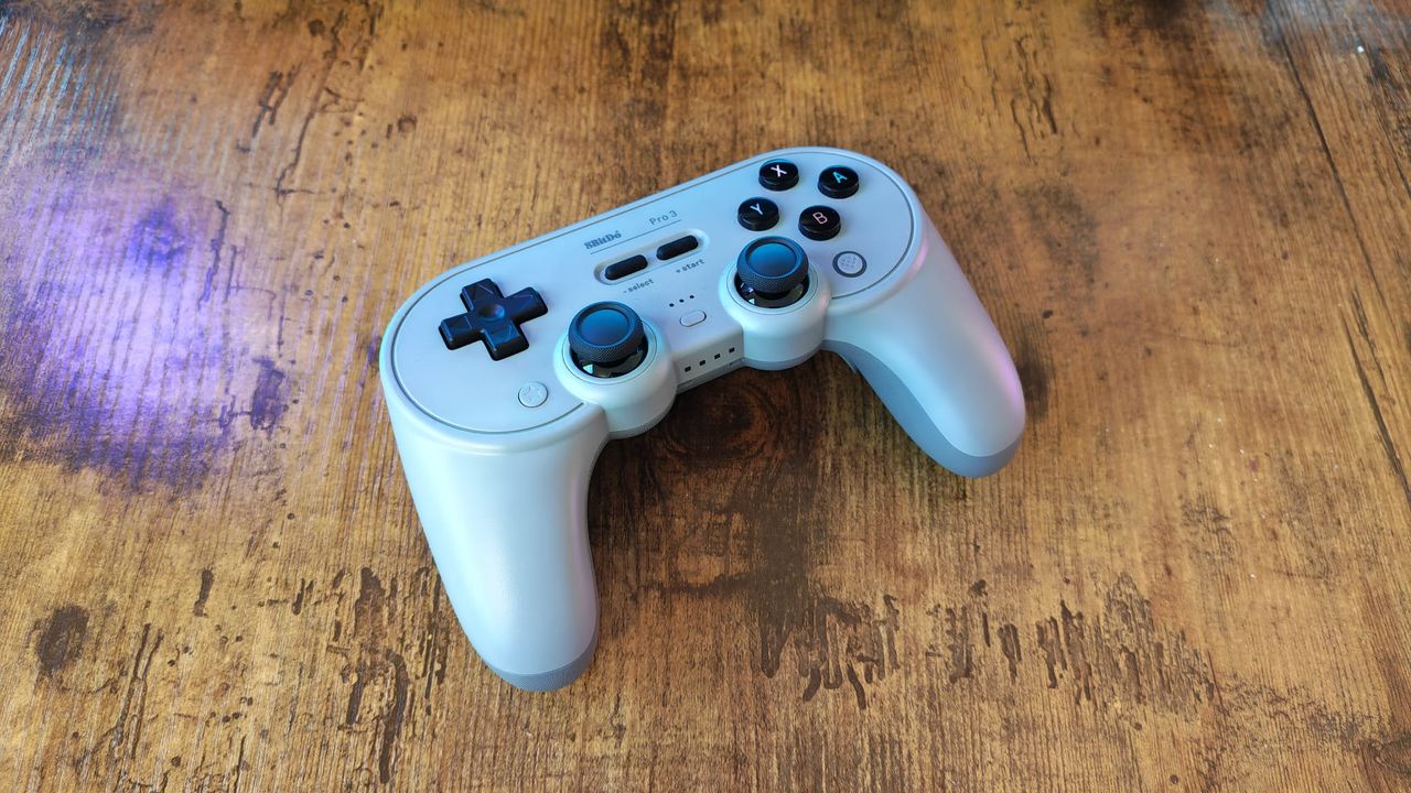 An 8BitDo Pro 3 review image showing the controller on a wooden desktop