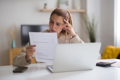 a woman surprised while reading a bill