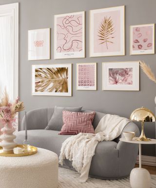grey living room with pink pictures and curved sofa