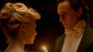 Mia Wasikowska and Tom Hiddleston share a romantic look over candlelight in Crimson Peak.