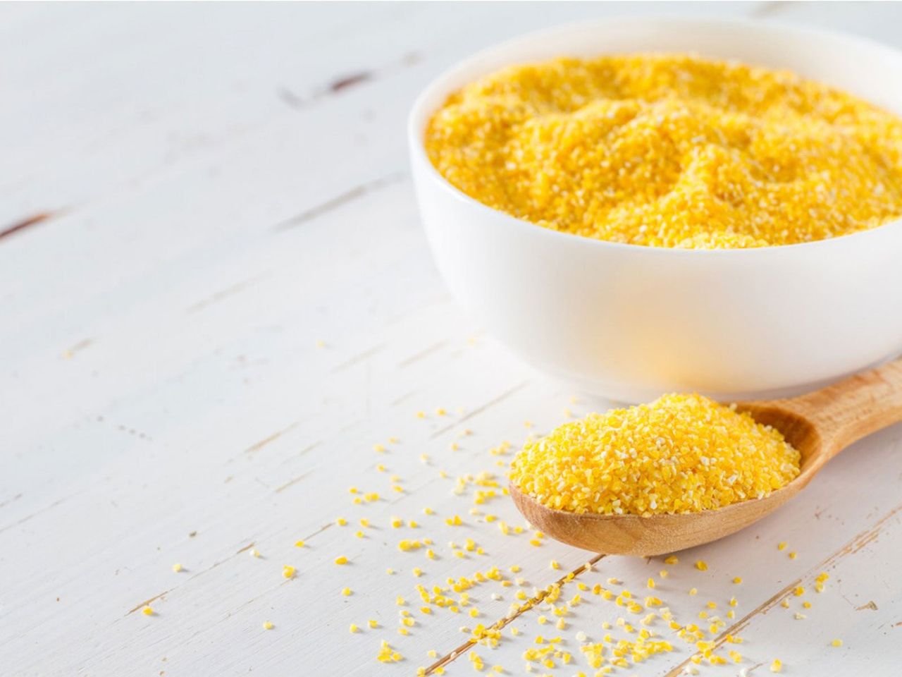 Bowl And Wooden Spoon Full Of Cornmeal