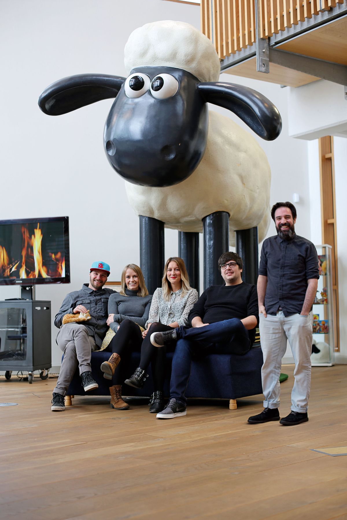 Aardman team posing in front of a Shaun the Sheep statue