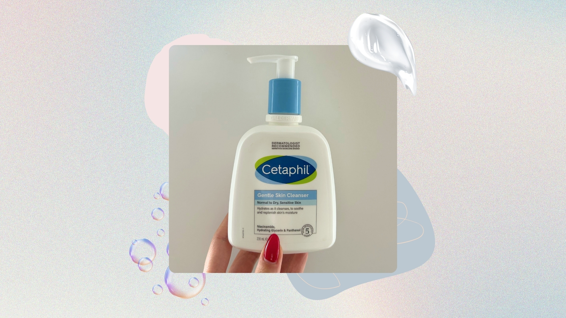 Image of hand with red almond nails holding a blue and white bottle of Cetaphil's Gentle Skin Cleanser, on a pastel watercolour background with blue and pink graphics, a swatch of cream and bubbles