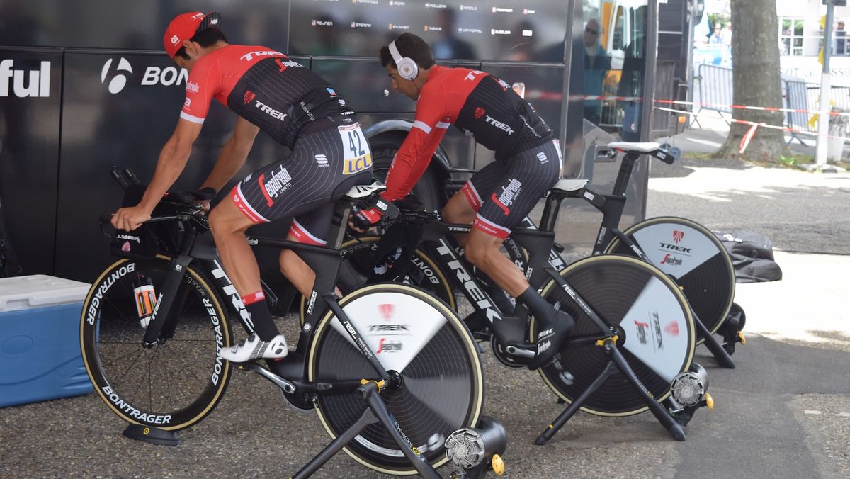 Trek-Segafredo riders warm-up in the shade ahead of the start in a sunny La Tour-Du-Pin