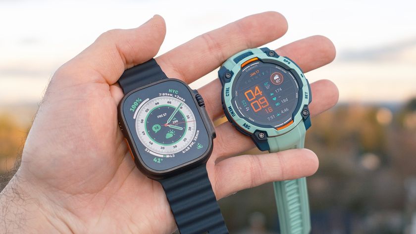 Close-up of the Apple Watch Ultra 2 (left) next to the Garmin Instinct 3 (right) in a user&#039;s hand