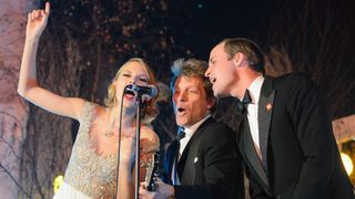 Prince William sings with US musicians Taylor Swift (L) and Jon Bon Jovi (C) at the Centrepoint Gala Dinner at Kensington Palace in London, on November 26, 2013
