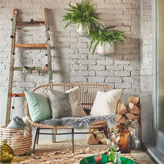 white brick wall pillows on chair and ladder with bulbs