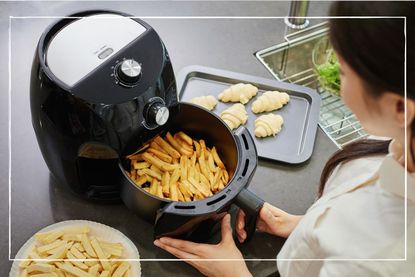Woman cooking fries in an air fryer