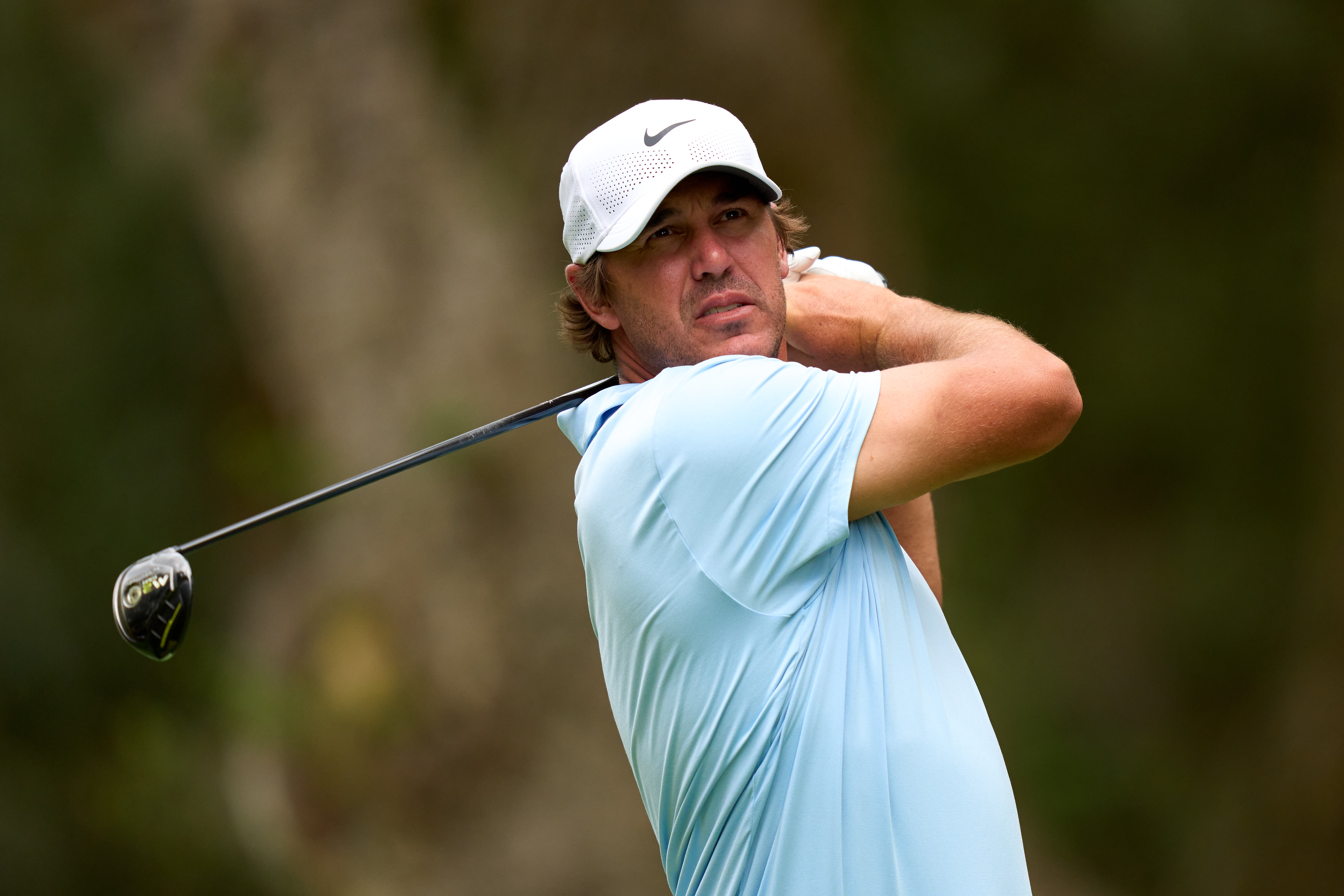 Brooks Koepka hits a fairway wood off the tee