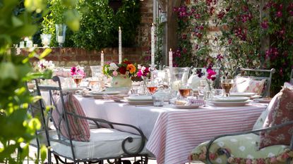 garden table with iron chairs and candles and lanterns